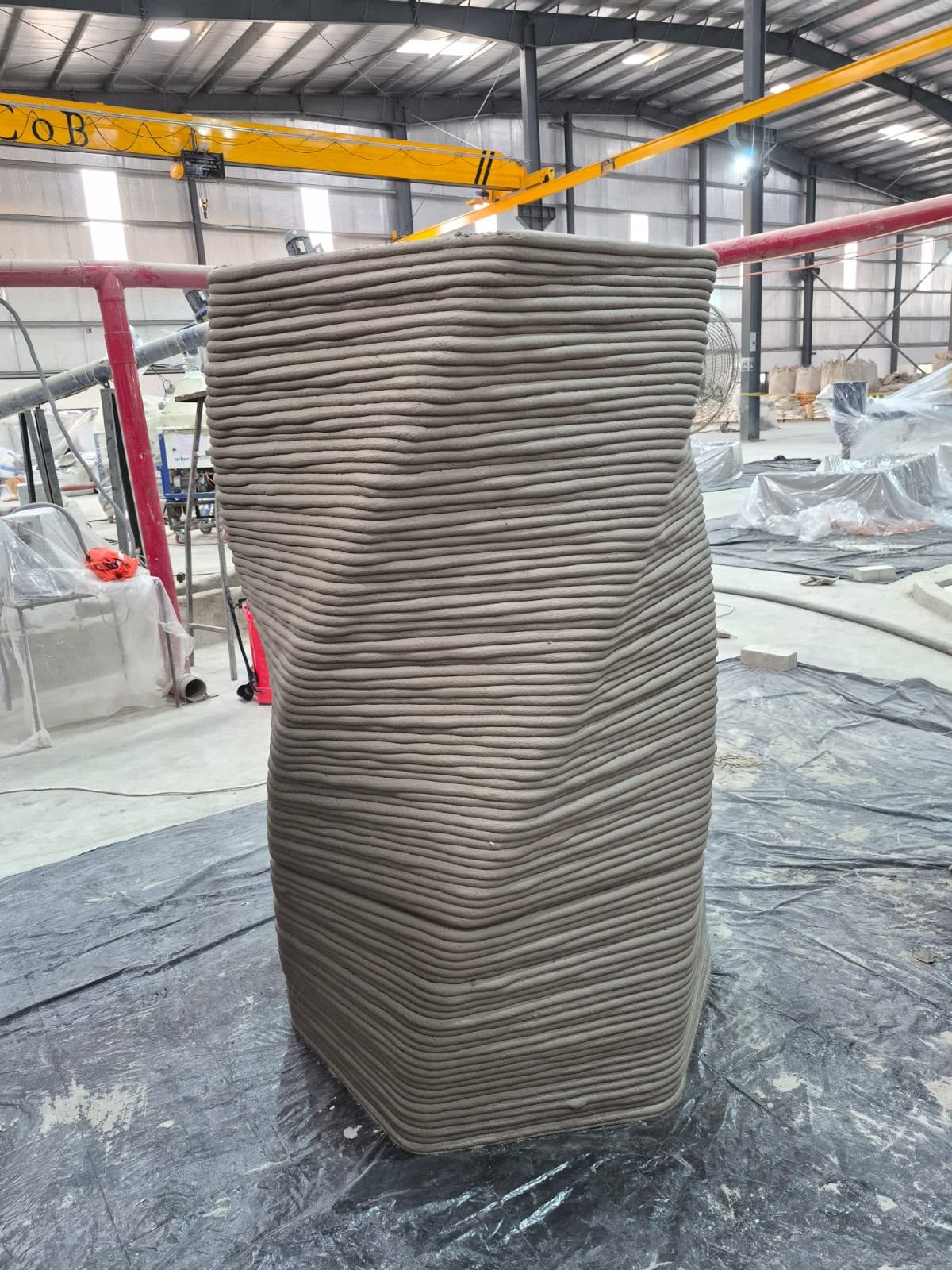 A tall printed concrete form with a continuous spiral surface.
